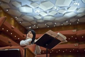 Composer Wang Jie in a concert hall, appearing at the Colorado Music Festival this summer in Boulder, CO