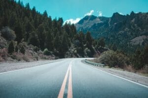 image of an empty road through the mountains | boulder colorado summer travel tips