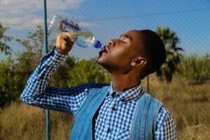 image of young man drinking water | boulder summer travel tips colorado music festival stay hydrated